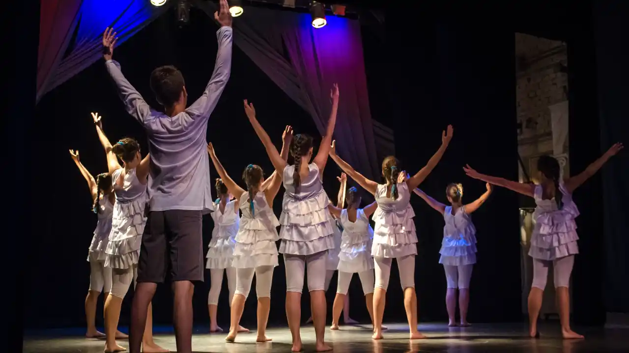Group of boys and girls performing in a children's Jazz Broadway class on stage