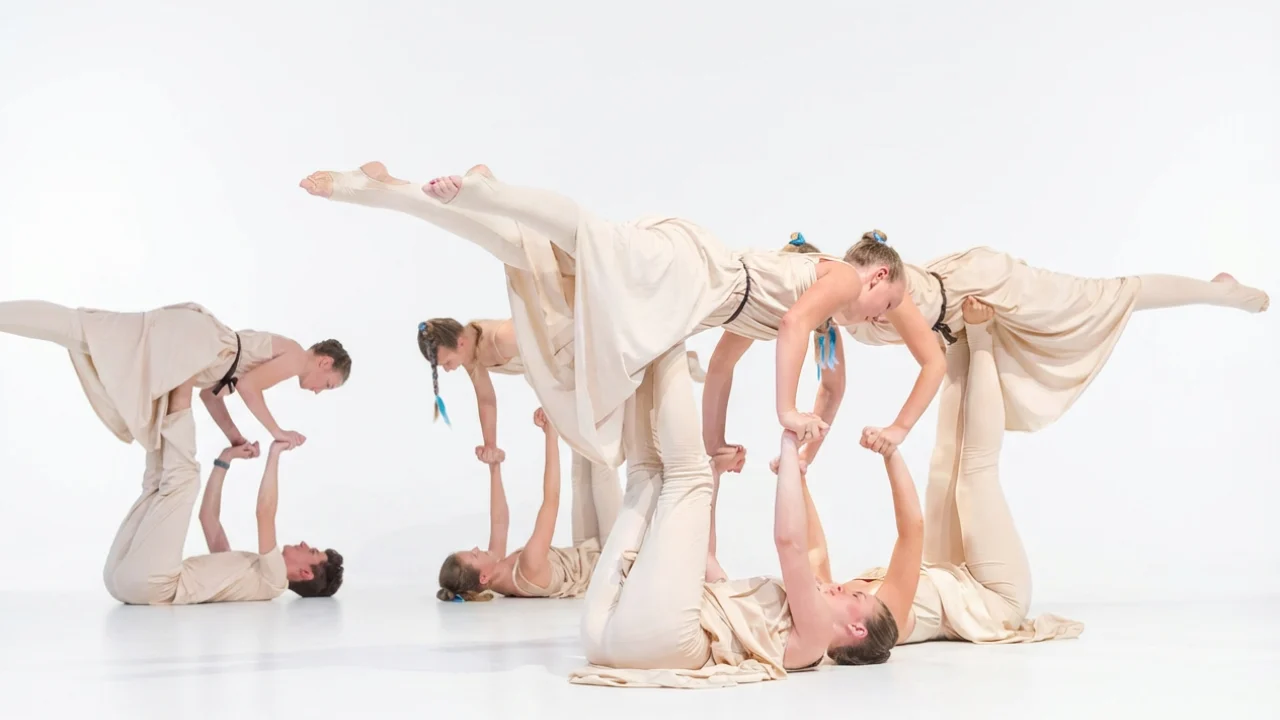 Teen Modern Jazz students rehearsing a lift pose in a photo studio